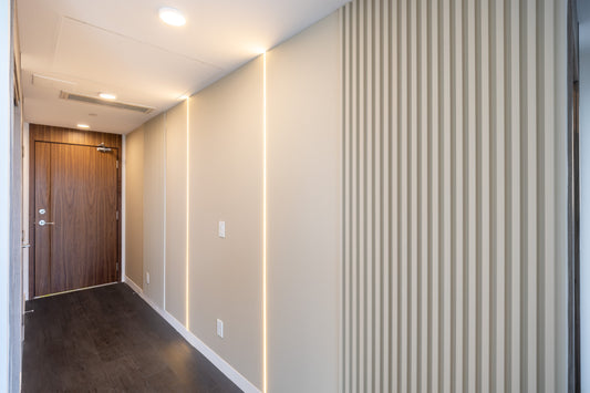 Modern condo hallway with milk white wall panels, vertical LED lighting, and slat wall panel design in North York model suite.