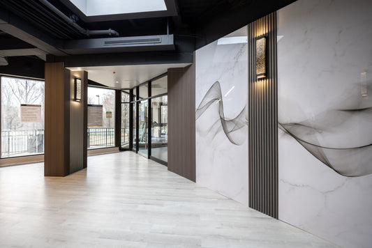Hospitality lobby interior with marble-look large wall panels, dark slat details, and warm wood-tone wall surfaces
