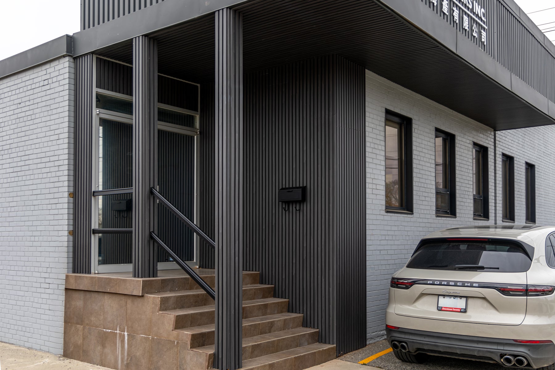 Wood Black exterior slat panels continuing across columns walls and soffit at an Etobicoke office entrance
