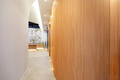 Natural wood flexible slat wall panels installed on a curved interior wall in Toronto