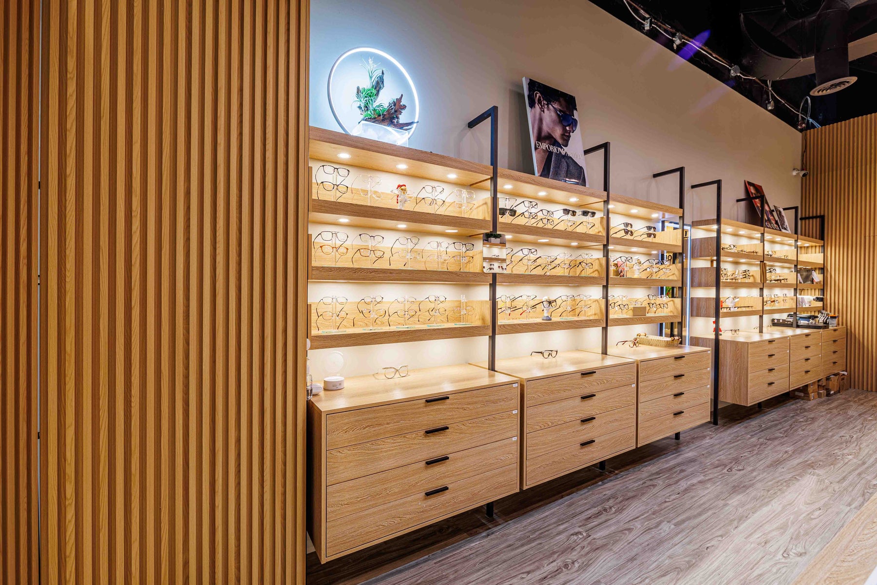 Natural Wood slat wall panels beside illuminated eyewear displays in a Markham optical shop