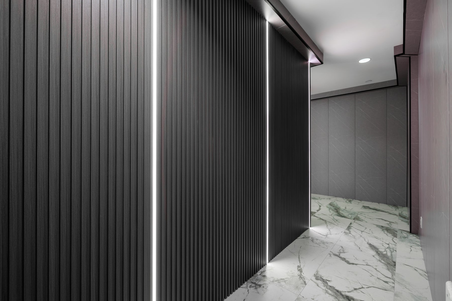Wood Black and Dark Gray slat wall panel corridor with integrated LED lighting in a Vaughan hotel by RichVaugh