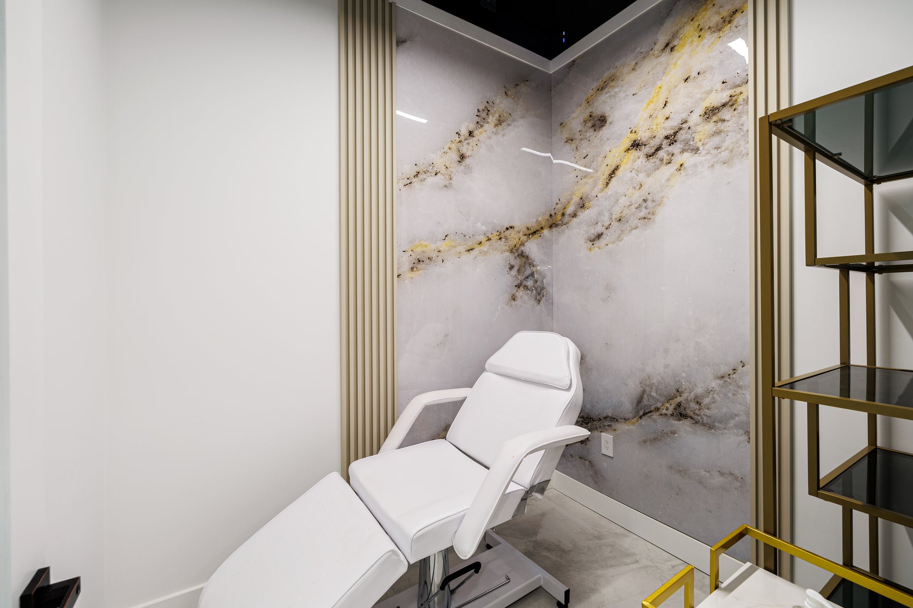 Metal Gold slat wall panel accent beside a beauty treatment room feature wall in Richmond Hill Ontario