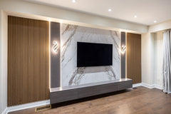 Angled view of custom marble TV wall with stone gray panels, oak slat panels and LED lighting in Alliston Ontario by RichVaugh