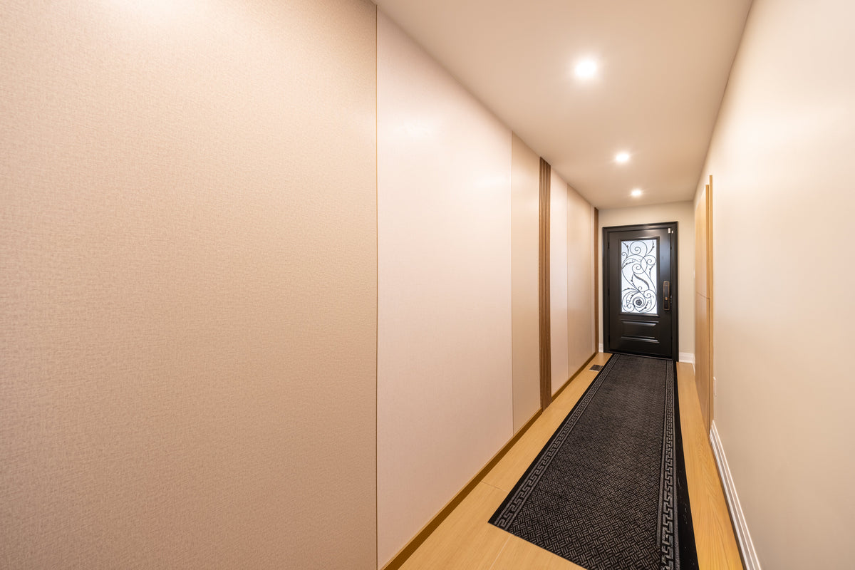 Grasscloth wall panels along the entrance hallway with wood-tone accents in a Markham whole-house project.
