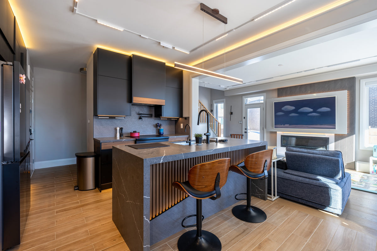 Open-plan kitchen and living room with gray finishes, a slat TV and fireplace feature wall and linear lighting in Markham, Ontario.