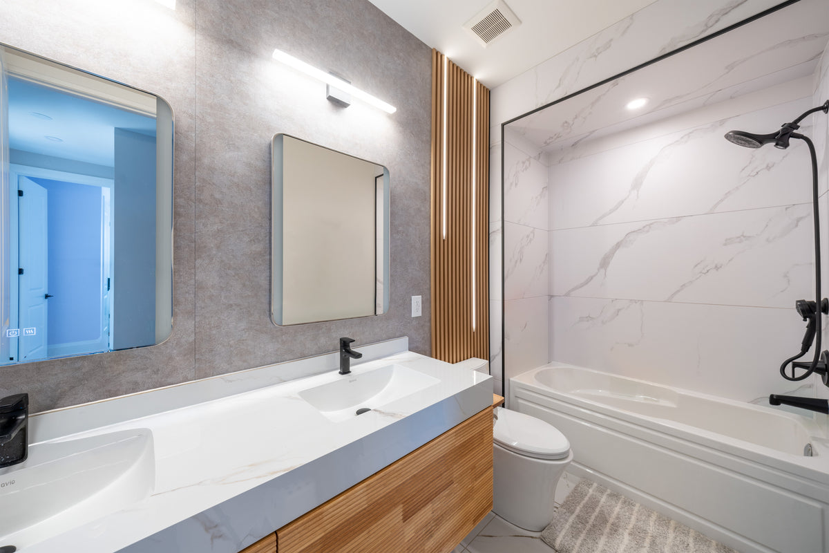 Bathroom with gray wall panels, a white marble-look bathtub surround and wood-tone slat accent in a Markham whole-house project.