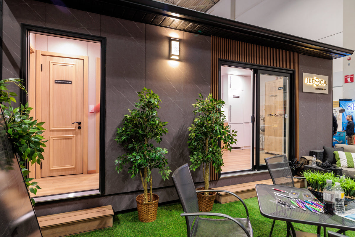 National Home Show 2023 display with dark exterior-style panels, entry doors and patio furniture.