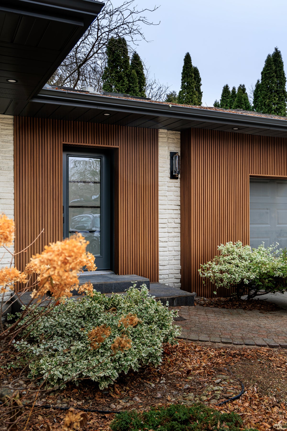 Wood Brown vertical slat exterior siding around a front door and garage in Niagara Falls.