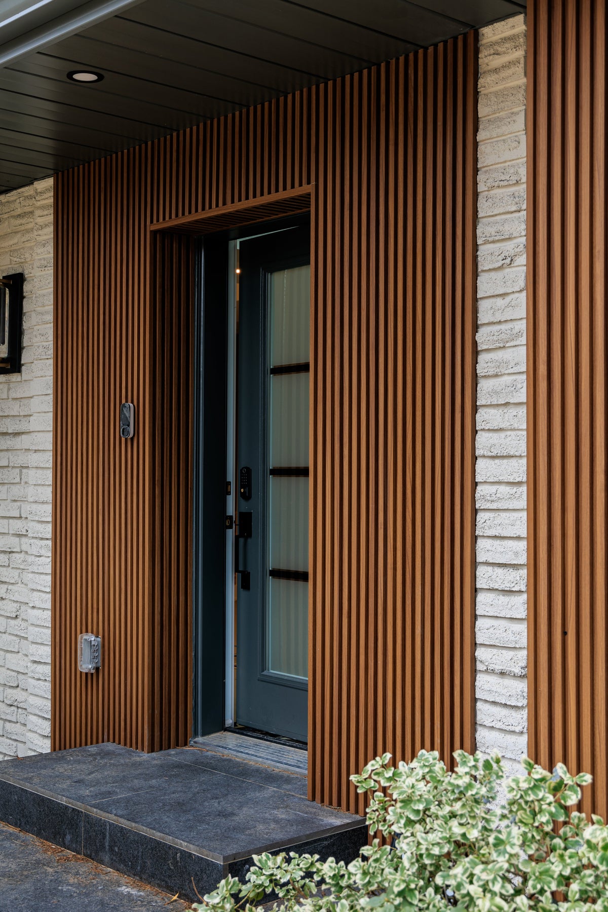 Close view of Wood Brown siding around a recessed front entrance in Niagara Falls.