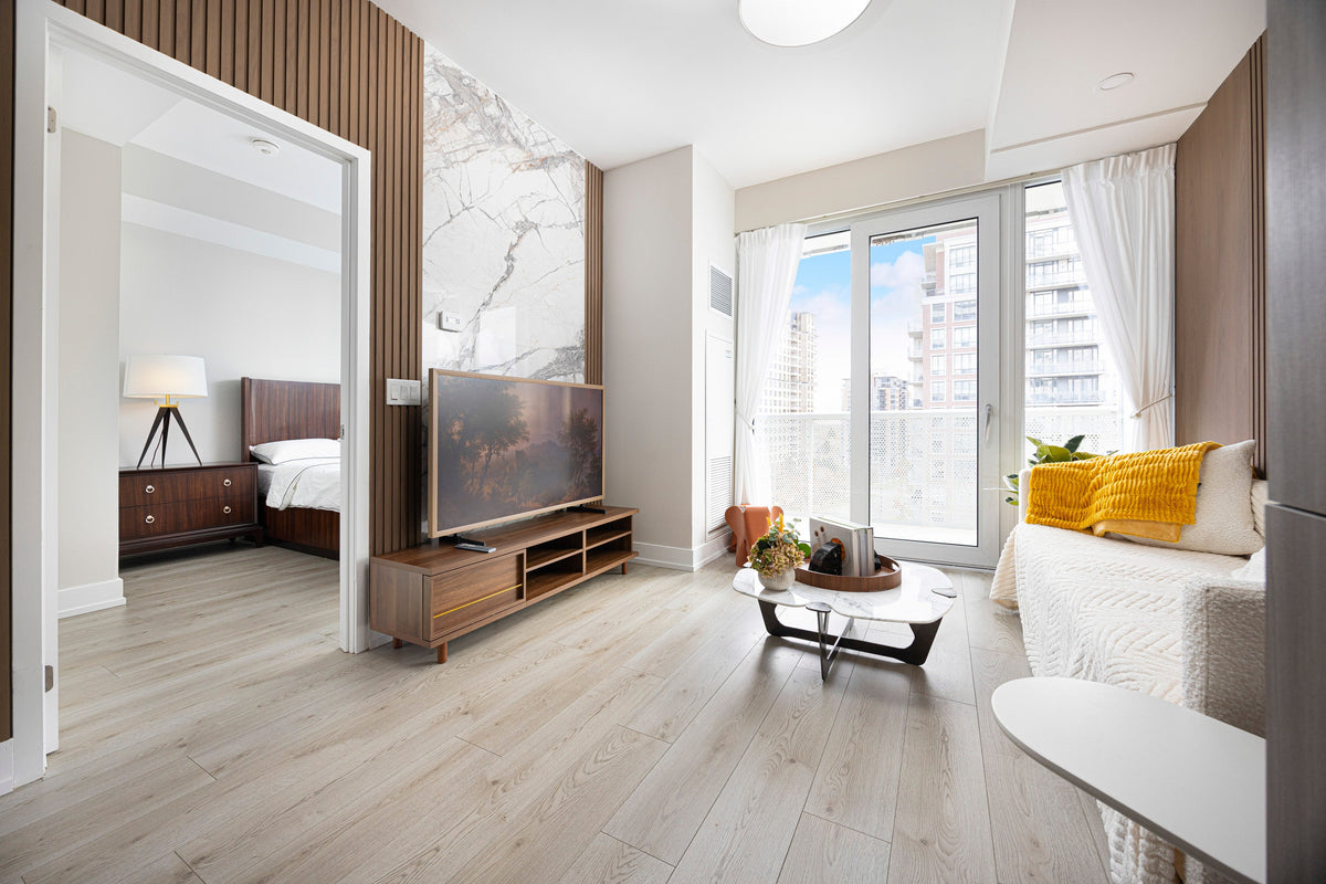 North York condo living room with wood-tone panels, slat accents, a marble-look TV wall and balcony doors.