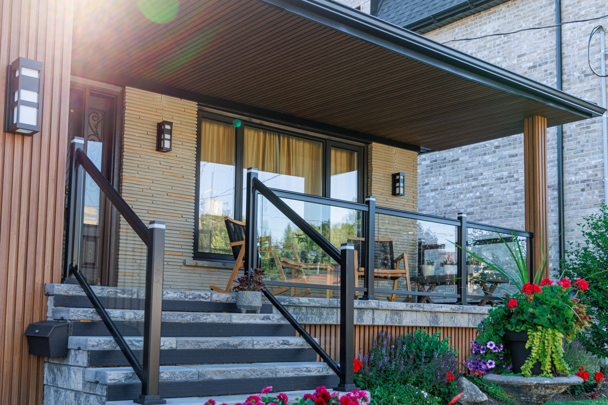 Covered front porch with brown slat siding, dark roof trim and black railings in Richmond Hill.