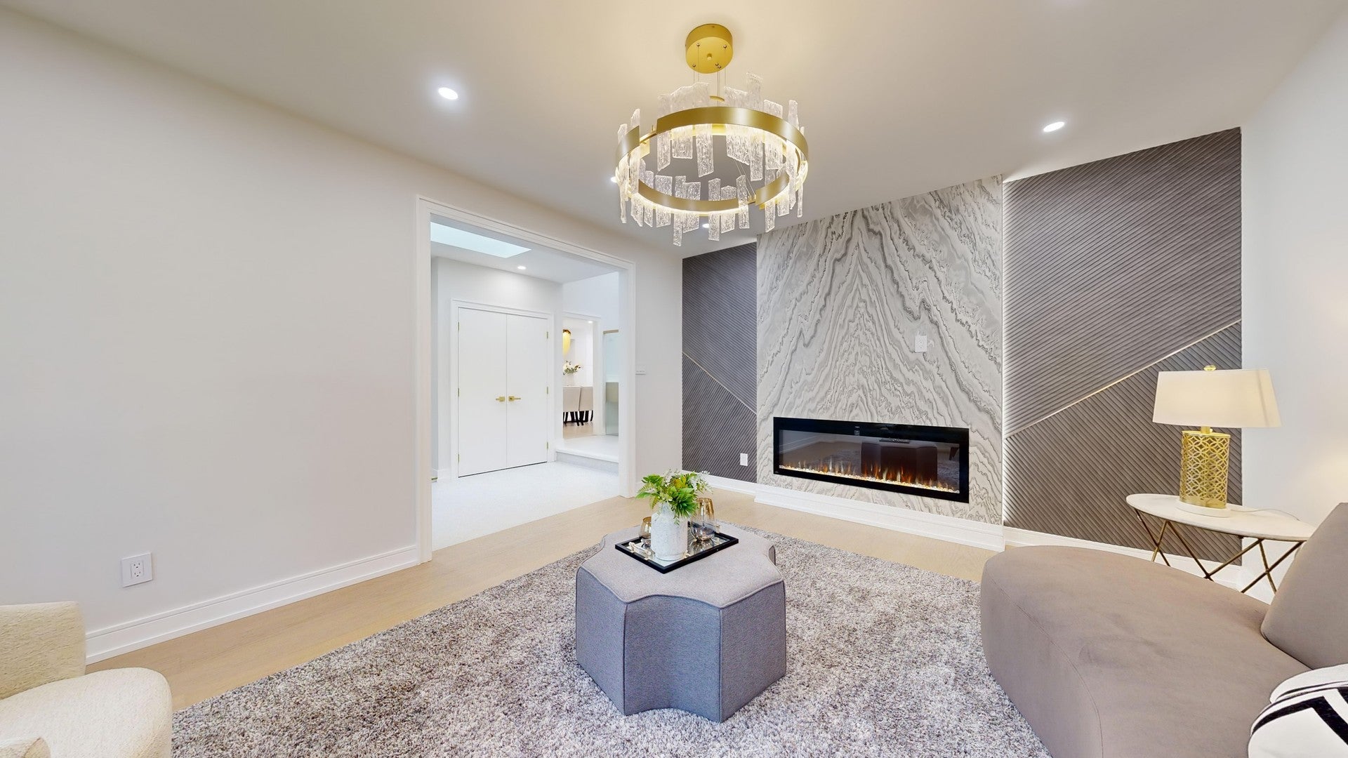 Modern living room fireplace accent wall with marble-look and fluted wall panels in a renovated home in Richmond Hill, Ontario.