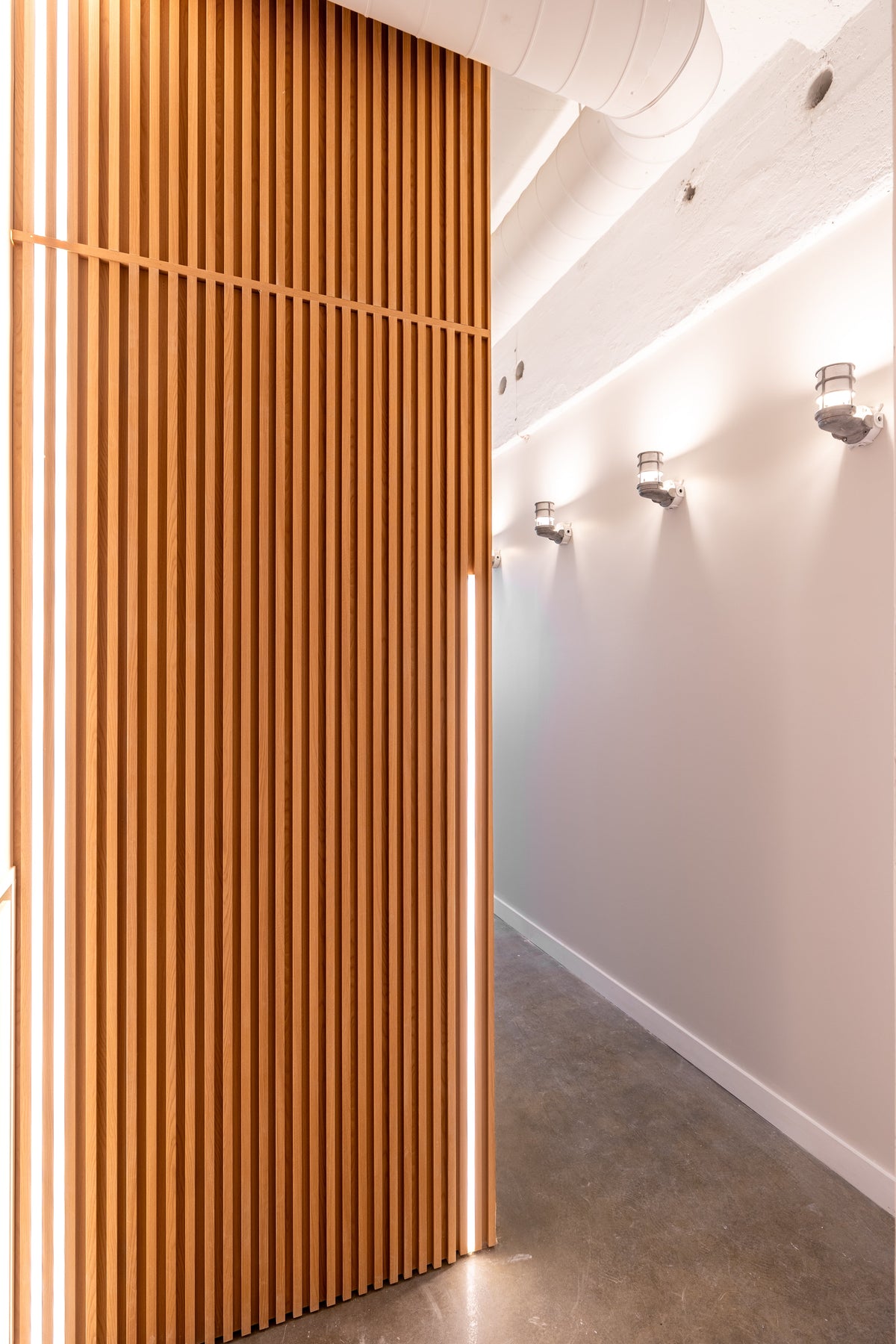 Natural Wood vertical slat entrance wall with linear lighting in a Toronto condo.