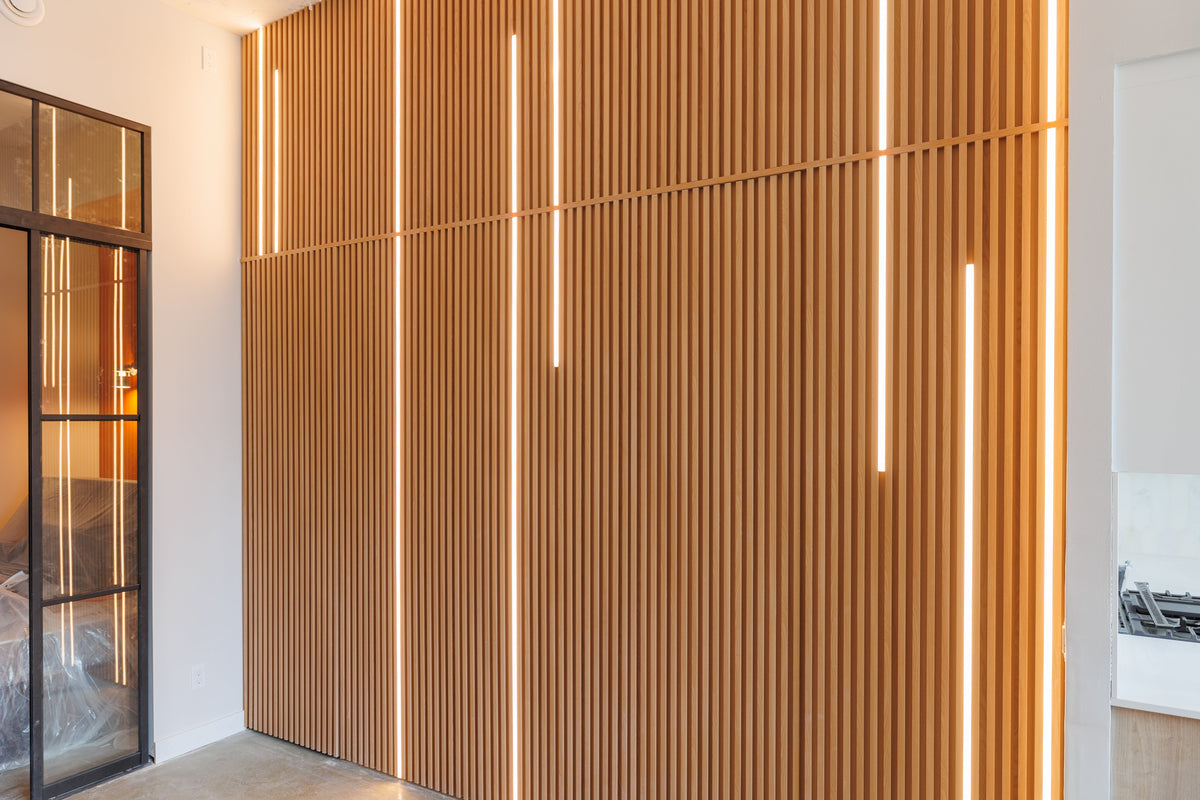 Tall Natural Wood slat accent wall with vertical light strips beside glass doors in Toronto.