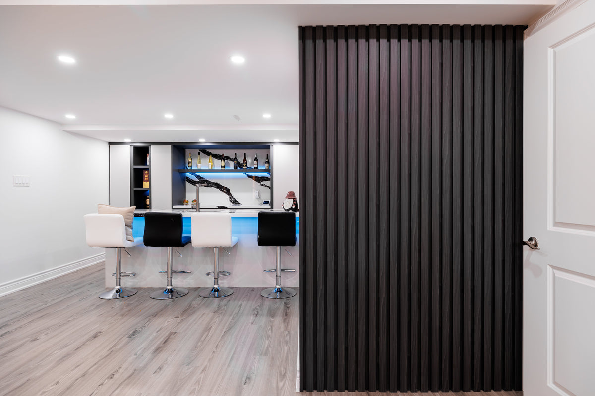 Black slat partition beside an open bar area in a Vaughan home.